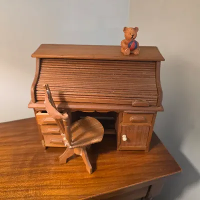 Sale Photo Thumbnail #69: Miniature wooden roll-top desk and matching swivel chair, topped with a small teddy bear figurine.