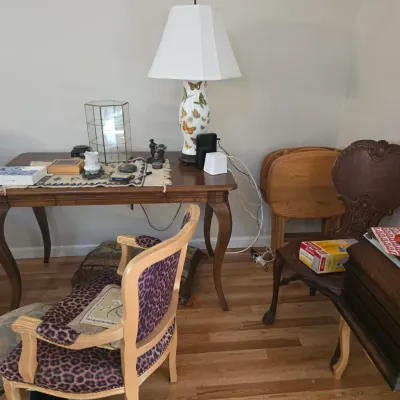 Sale Photo Thumbnail #72: French Provincial style wooden writing desk with cabriole legs, paired with an eclectic mix of seating including a leopard-print upholstered armchair and an ornate carved wood chair.