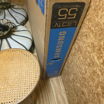 Sale Photo Thumbnail #205: Samsung 55-inch LED TV box standing upright next to a round cane-seat stool and two vintage slag glass hanging lamps.