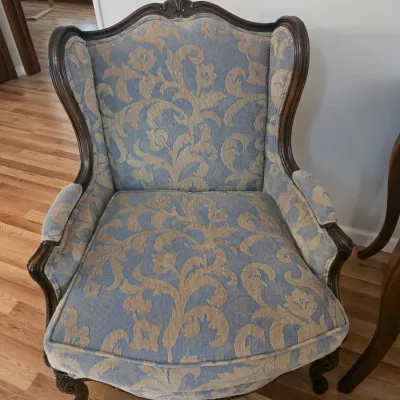 Sale Photo Thumbnail #78: Vintage French Provincial style wingback armchair featuring blue and gold damask upholstery and a carved dark wood frame.