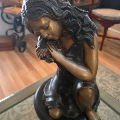 Sale Photo Thumbnail #51: Bronze-finished resin sculpture of a kneeling young woman with long hair, mounted on a circular black base.