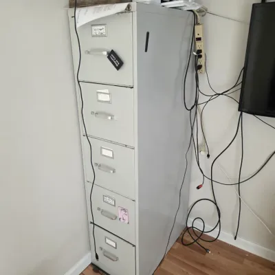 Sale Photo Thumbnail #88: Vintage five-drawer metal filing cabinet in a light gray finish, showing some wear and tear from use.