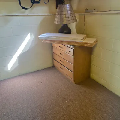 Sale Photo Thumbnail #187: Vintage wooden four-drawer chest of drawers with a table lamp featuring a tiled shade, shown with loose shelving boards stacked on top.