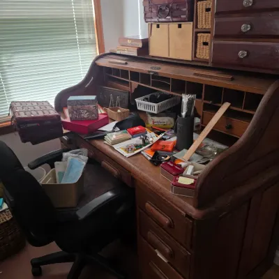 Sale Photo Thumbnail #103: Vintage oak rolltop desk with multiple drawers and cubbies, paired with a modern black rolling office chair.