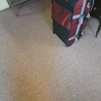 Sale Photo Thumbnail #189: Large burgundy and black rolling suitcase with multiple zippered compartments and a telescoping handle.