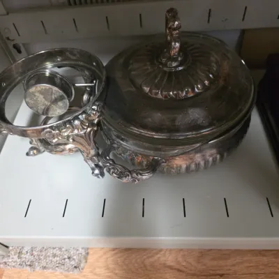 Sale Photo Thumbnail #140: Vintage silver-plated chafing dish with an ornate lid, handles, and matching burner stand, showing some tarnish.