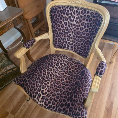 Sale Photo Thumbnail #77: French provincial style armchair featuring a light wood frame with carved details and leopard print upholstery accented by brass nailhead trim.