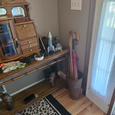 Sale Photo Thumbnail #178: Vintage oak entryway console table featuring a faux-bamboo frame, paired with a matching tabletop secretary desk, a metal umbrella stand, and various decorative collectibles.