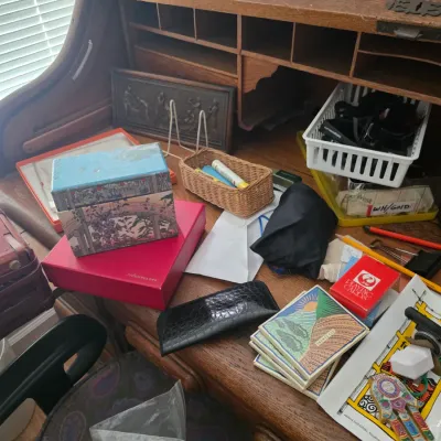 Sale Photo Thumbnail #105: Vintage rolltop desk cluttered with various office supplies, decorative boxes, coasters, and small storage baskets.