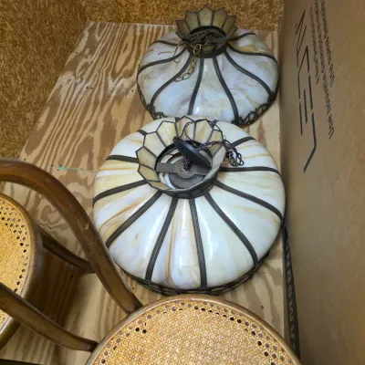 Sale Photo Thumbnail #206: Pair of vintage slag glass hanging pendant light fixtures with cream and amber panels, shown alongside bentwood chairs with cane seats.