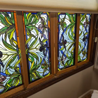 Sale Photo Thumbnail #144: Four-panel stained glass window installation featuring an Art Nouveau-style design with irises, orchids, and flowing green foliage.
