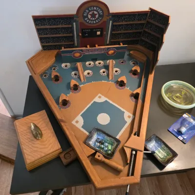 Sale Photo Thumbnail #63: Vintage-style Old Century Baseball wooden pinball game, featuring a stadium backdrop, spring-loaded plunger, and marbles.