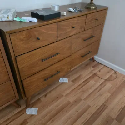 Sale Photo Thumbnail #93: Mid-century modern style wooden dresser featuring a mix of small knob pulls and long bar handles on tapered legs.