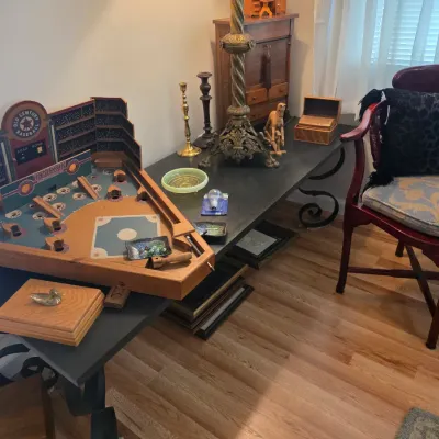 Sale Photo Thumbnail #62: Vintage Old Century Baseball pinball game displayed on a black console table alongside brass candlesticks, an ornate lamp, and a mahogany armchair with patterned cushions.