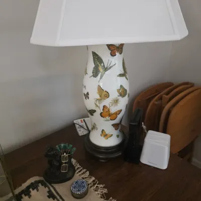 Sale Photo Thumbnail #83: Vintage ceramic table lamp featuring a colorful butterfly motif on a white background, mounted on a dark wooden base with a white rectangular shade.