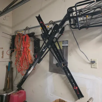 Sale Photo Thumbnail #165: Swagman platform-style hitch bike rack mounted on a garage wall, shown alongside extension cords and other garage storage items.