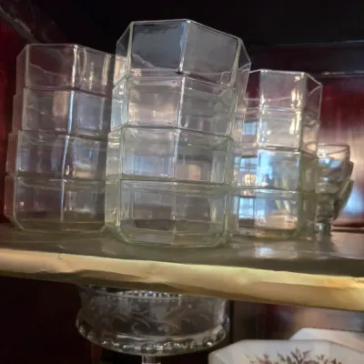 Sale Photo Thumbnail #21: Stacks of vintage octagonal clear glass dessert bowls, displayed on a shelf.
