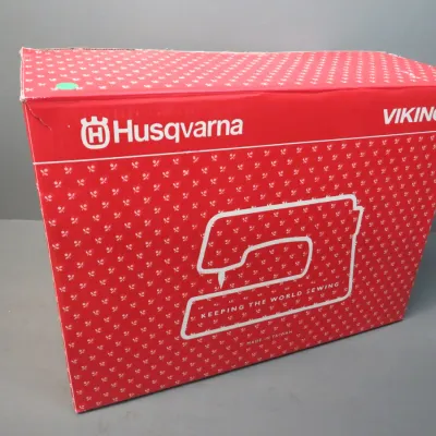 Sale Photo Thumbnail #20: Husqvarna Viking sewing machine in its original red and white patterned box, showing some light wear on the corners.