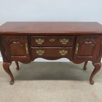 Sale Photo Thumbnail #4: Queen Anne style cherry buffet featuring two central drawers with ornate brass pulls, flanked by two side cabinets, supported by elegant cabriole legs.