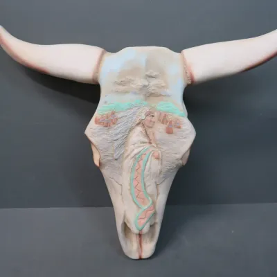 Sale Photo Thumbnail #19: Southwestern-style ceramic steer skull wall hanging, featuring a relief carving of a Native American figure and tipis in pastel tones.