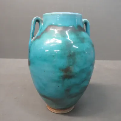 Sale Photo Thumbnail #32: Vintage art pottery urn-style vase featuring a vibrant turquoise glaze with dark, smoky underglaze accents and two small loop handles.