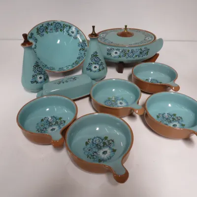 Sale Photo Thumbnail #25: Vintage mid-century ceramic serving set featuring a turquoise interior with blue floral patterns and brown exteriors, including handled bowls, a covered casserole dish, a butter dish, and cruets.