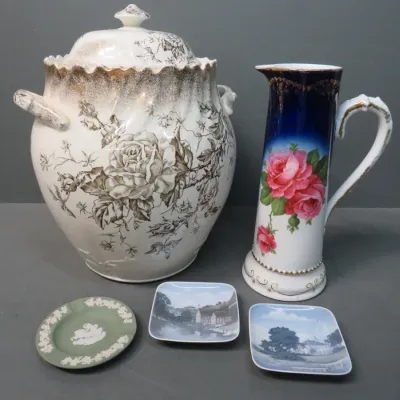 Sale Photo Thumbnail #23: Vintage porcelain collection featuring a large lidded urn with sepia floral transferware, a cobalt blue and pink rose pitcher, and three small decorative dishes including a green Wedgwood jasperware piece.
