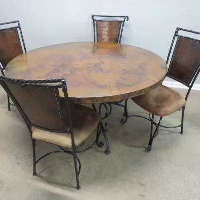 Sale Photo Thumbnail #38: Rustic round dining table with a hammered copper top and wrought iron base, accompanied by four matching chairs featuring copper-paneled backs and upholstered seats.