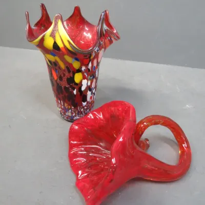 Sale Photo Thumbnail #41: Murano-style art glass pieces, including a multi-colored confetti glass vase with a ruffled rim and a vibrant red glass horn-shaped basket with a looped handle.