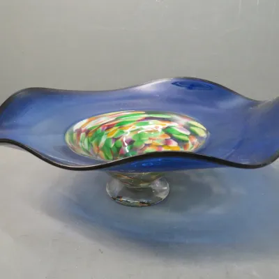 Sale Photo Thumbnail #18: Art glass pedestal bowl featuring a wide, wavy cobalt blue rim and a colorful, multi-toned confetti glass center.
