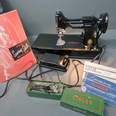 Sale Photo Thumbnail #21: Vintage Singer Featherweight 221 portable sewing machine with foot pedal, instruction manuals, reference book, and accessory box.
