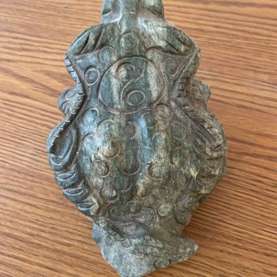 Sale Photo Thumbnail #55: A hand-carved decorative frog figurine crafted from a green stone, possibly soapstone or jadeite.