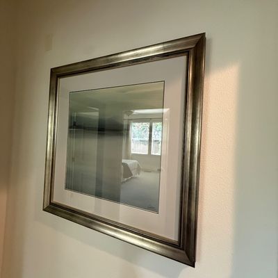 Framed landscape art print featuring a misty, minimalist scene, presented in a wide white mat and a metallic silver-finished frame.