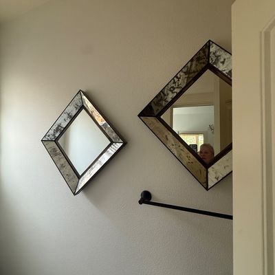 Pair of contemporary diamond-shaped wall mirrors featuring antiqued, distressed glass frames.