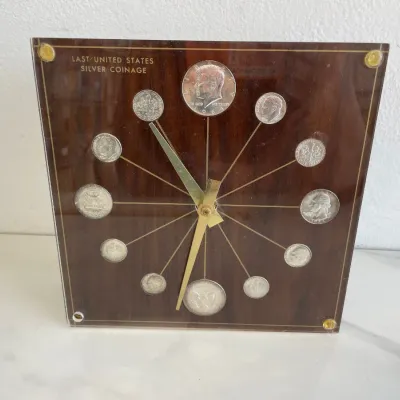 Sale Photo Thumbnail #152: Vintage Marion-Kay 'Last United States Silver Coinage' desk clock featuring 1964 silver coins set in a lucite and faux-wood grain face.