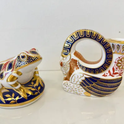 Sale Photo Thumbnail #263: Royal Crown Derby Imari style porcelain paperweight figurines, featuring a frog on a lily pad and a stylized ram, decorated with rich cobalt blue, iron red, and 22-karat gold gilding.