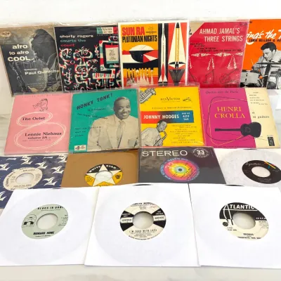 Sale Photo Thumbnail #190: Collection of vintage jazz and pop vinyl records, including 7-inch 45 RPM singles and EP albums from artists like Sun Ra, Johnny Hodges, and Lennie Niehaus on labels such as RCA Victor, Columbia, and Atlantic.