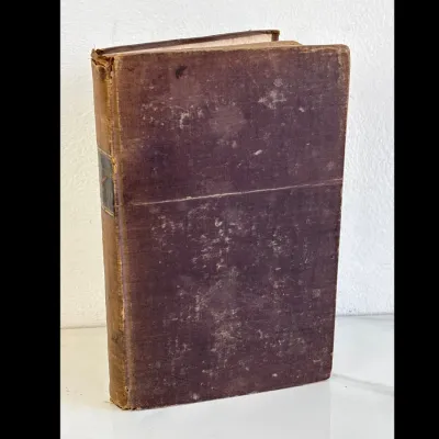 Sale Photo Thumbnail #202: Antique hardcover book featuring a heavily worn purple cloth cover and a faded leather spine, showing significant age-related wear and patina.