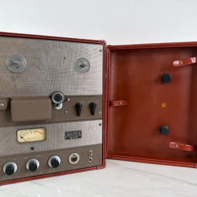 Sale Photo Thumbnail #163: Vintage Ampex 600 portable reel-to-reel tape recorder, housed in its original brown carrying case with a built-in VU meter and analog control knobs.
