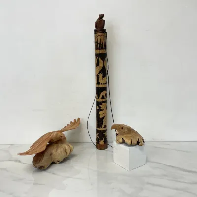 Sale Photo Thumbnail #417: Collection of hand-carved wooden folk art, including a tall bamboo container with etched animal figures, a carved eagle in flight on a burl wood base, and a carved eagle head sculpture.