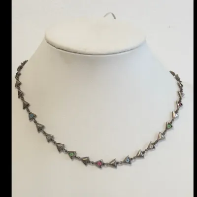 Sale Photo Thumbnail #165: Vintage sterling silver link necklace featuring a series of small triangular stations, some set with colorful pastel rhinestones, displayed on a white jewelry bust.