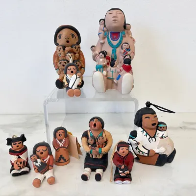 Sale Photo Thumbnail #220: Collection of Native American storyteller pottery figurines, including Cochiti Pueblo style clay sculptures depicting mothers and children, hand-painted with traditional geometric patterns.