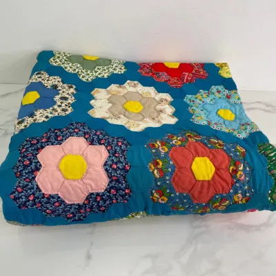Sale Photo Thumbnail #384: Vintage handmade Grandmother's Flower Garden quilt featuring colorful hexagon patchwork blocks on a vibrant blue background.