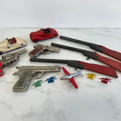 Sale Photo Thumbnail #235: Collection of vintage cast iron and die-cast metal toys, including Hubley and Kilgore cap guns, Hubley toy cars, a Hubley toy airplane, and miniature plastic horses.
