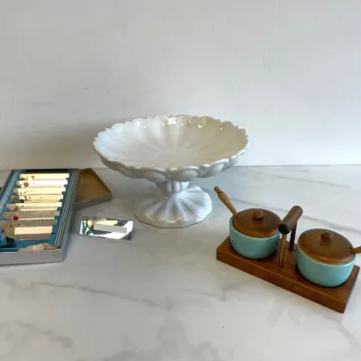 Sale Photo Thumbnail #153: Vintage tabletop decor including a white ceramic pedestal cake stand, a mid-century modern teak and turquoise ceramic condiment set with wooden spoons, and a boxed set of floral place card holders.