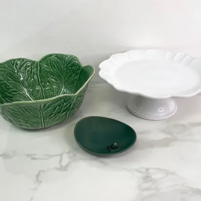 Sale Photo Thumbnail #395: Bordallo Pinheiro green cabbage leaf ceramic bowl, paired with a white ceramic pedestal cake stand and a small dark green frog trinket dish.