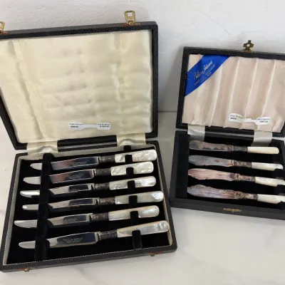 Sale Photo Thumbnail #256: Two vintage English boxed sets of mother-of-pearl handled knives, including a Kent Silversmiths Sheffield stainless steel fish knife set and a William Adams Sheffield silver-plated fruit knife set.