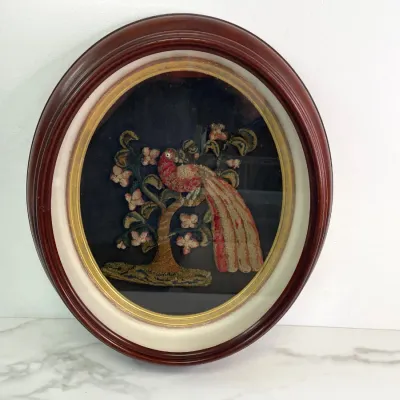 Sale Photo Thumbnail #28: Antique Victorian-era Stumpwork embroidery depicting a bird of paradise in a tree, housed in a deep oval mahogany shadow box frame with a gold-painted inner bezel.