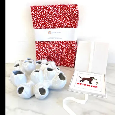 Sale Photo Thumbnail #360: Amelie Michel red and white patterned French tablecloth, paired with a white ceramic multi-opening tulipiere vase and a boxed set of embroidered 'Retriever' cocktail napkins.