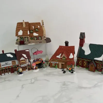 Sale Photo Thumbnail #397: Department 56 Dickens' Village Series collectible Christmas village buildings and figurines, including "The Old Curiosity Shop" and "Rare Books" shops, in excellent vintage condition.